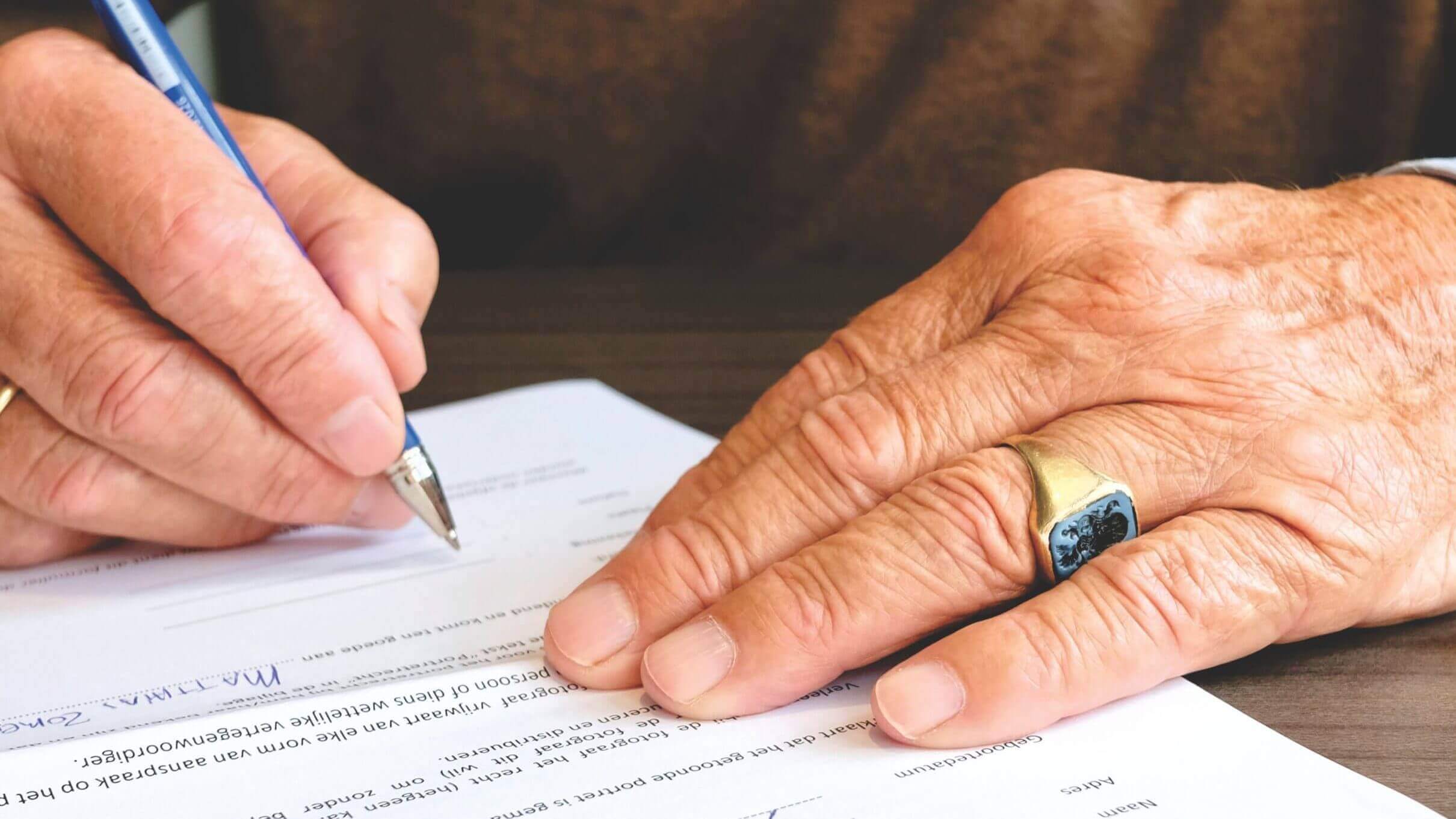 hands signing a Last Will and Testament